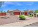 Attractive single-story home with a red garage door, desert landscaping, and solar panels at 11306 E Rembrandt Ave, Mesa, AZ 85212
