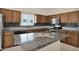 Kitchen features wooden cabinetry, stainless steel appliances, and granite countertops with decorative tile backsplash at 11306 E Rembrandt Ave, Mesa, AZ 85212