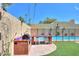 Outdoor kitchen with built-in grill and a view of the backyard swimming pool at 1131 N Cherry --, Mesa, AZ 85201