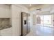 Updated kitchen featuring stainless steel refrigerator, white cabinets, granite countertops, and tiled flooring with a view to the backyard at 1131 N Cherry --, Mesa, AZ 85201