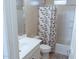 Bathroom features a vanity sink, toilet, and shower with a stylish patterned curtain, all brightly lit and functional at 1183 S Tumbleweed Ln, Chandler, AZ 85286