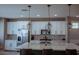 Kitchen with white cabinets, quartz countertop island, stainless appliances, and chandelier-style pendant lights at 1183 S Tumbleweed Ln, Chandler, AZ 85286