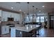 Open kitchen with white cabinets, quartz countertops, island seating, and stainless steel appliances at 1183 S Tumbleweed Ln, Chandler, AZ 85286