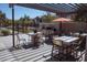 Outdoor dining area under a pergola with modern tables, chairs, and a built-in grill at 1183 S Tumbleweed Ln, Chandler, AZ 85286