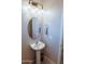 This powder room has an oval mirror, unique lighting fixture, and single sink at 1183 S Tumbleweed Ln, Chandler, AZ 85286
