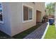 View of the side yard featuring faux grass, brick pavers, and the exterior walls of the home at 1183 S Tumbleweed Ln, Chandler, AZ 85286