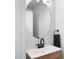 Modern bathroom features a round mirror, dark faucet, and wooden cabinet at 1236 S Boulder St # C, Gilbert, AZ 85296