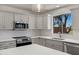 Bright kitchen features white cabinets, stainless steel appliances, and quartz countertops at 1236 S Boulder St # C, Gilbert, AZ 85296