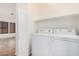 Laundry room with a full-size white washer and dryer, and a small shelf at 125 N 22Nd Pl # 128, Mesa, AZ 85213