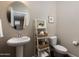 Stylish powder room featuring a pedestal sink, oval mirror, and decorative ladder shelf for a modern look at 1255 N Arizona Ave # 1013, Chandler, AZ 85225