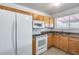 Well-equipped kitchen featuring white appliances, tile floors, and natural wood cabinets at 12602 N 38Th Ave, Phoenix, AZ 85029