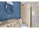 Bathroom featuring a round mirror, vanity, toilet, and tiled shower with light fixtures at 12842 S Wakial Loop, Phoenix, AZ 85044