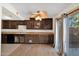 Kitchen featuring wooden floors, wooden cabinets, and a glass sliding door to the exterior at 12842 S Wakial Loop, Phoenix, AZ 85044
