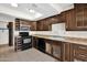 Kitchen featuring dark wood cabinets and black appliances at 12842 S Wakial Loop, Phoenix, AZ 85044