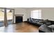 Bright living room with hardwood floors, fireplace, couch, and sliding glass door to patio at 12842 S Wakial Loop, Phoenix, AZ 85044