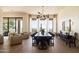 Elegant dining room with a large table, modern chandelier, and floor-to-ceiling windows with views at 12887 N 135 St, Scottsdale, AZ 85259