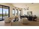 Dining area with comfortable seating, modern chandelier, and exterior views of desert landscape at 12887 N 135 St, Scottsdale, AZ 85259