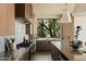 Sleek kitchen with wood cabinets, stainless steel appliances, marble counters, and a bright window overlooking lush greenery at 12887 N 135 St, Scottsdale, AZ 85259