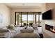 Spacious living room with a modern fireplace, plush seating, scenic outdoor views, and seamless indoor-outdoor flow at 12887 N 135 St, Scottsdale, AZ 85259