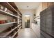Well-organized pantry with ample shelving, a stainless steel refrigerator, and exterior views at 12887 N 135 St, Scottsdale, AZ 85259