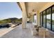 Expansive covered patio with travertine flooring, outdoor seating, and views of the desert landscape at 12887 N 135 St, Scottsdale, AZ 85259