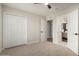 Bright carpeted bedroom has a ceiling fan, large closet, and open bathroom doorway at 1352 W Naranja Ave, Mesa, AZ 85202