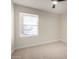 This bedroom features neutral carpeting, a window with blinds, and a modern ceiling fan at 1352 W Naranja Ave, Mesa, AZ 85202