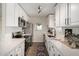 Galley kitchen featuring white cabinetry, stainless steel appliances, and light countertops at 1352 W Naranja Ave, Mesa, AZ 85202