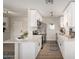 Bright kitchen with white cabinetry, modern appliances, and wood-look flooring, complemented by stylish decor at 1352 W Naranja Ave, Mesa, AZ 85202