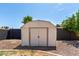 View of a backyard storage shed surrounded by a gravel yard and brick wall, offering practical outdoor storage at 1352 W Naranja Ave, Mesa, AZ 85202