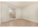 A neutral-toned bedroom with tile flooring and a large window providing natural light at 1439 N 53Rd Ave, Phoenix, AZ 85043