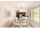 Dining area with glass table, white chairs, modern chandelier and view to the kitchen at 1439 N 53Rd Ave, Phoenix, AZ 85043