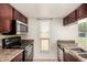 Well-lit kitchen with stainless steel microwave, dark wood cabinets, and a garden view at 1439 N 53Rd Ave, Phoenix, AZ 85043