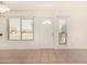A well-lit living room featuring tile floors and windows on either side of the entrance door at 1439 N 53Rd Ave, Phoenix, AZ 85043