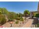 Well-maintained backyard with lush landscaping, including stone, rocks and shrubs at 1628 E Aspen Ave, Buckeye, AZ 85326