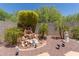 Zen backyard featuring a water fountain, gravel landscaping, palm trees, and outdoor ornaments at 1628 E Aspen Ave, Buckeye, AZ 85326