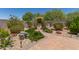 Beautiful landscaped backyard featuring a stone pathway, lush greenery, and decorative statues at 1628 E Aspen Ave, Buckeye, AZ 85326