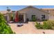 Outdoor patio with brick pavers, umbrella, and outdoor seating; landscaping around the house adds charm at 1628 E Aspen Ave, Buckeye, AZ 85326