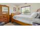 Comfortable bedroom with a wooden bed frame, dresser, and a large mirror at 1628 E Aspen Ave, Buckeye, AZ 85326