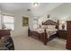 Primary bedroom showcasing a decorative wood bed frame, soft lighting, and neutral tones at 1628 E Aspen Ave, Buckeye, AZ 85326
