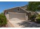 The home features a two-car garage, mature trees, and inviting curb appeal at 1628 E Aspen Ave, Buckeye, AZ 85326