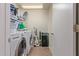 Laundry room with modern washer and dryer, storage shelves, and well-maintained tile flooring at 1628 E Aspen Ave, Buckeye, AZ 85326