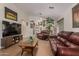 Inviting living room with a flat-screen TV and comfortable leather seating, perfect for relaxing at 1628 E Aspen Ave, Buckeye, AZ 85326