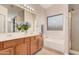 Well-lit bathroom featuring double sinks, a soaking tub, and a separate shower stall at 16288 W Hadley St, Goodyear, AZ 85338