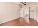 Bright bedroom with tile floors, ceiling fan, and mirrored closet at 16288 W Hadley St, Goodyear, AZ 85338