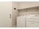 Functional laundry room with overhead shelving, a door to the house, and neutral paint at 16288 W Hadley St, Goodyear, AZ 85338