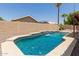 Backyard pool with waterfall feature surrounded by desert landscaping and block fence at 16288 W Hadley St, Goodyear, AZ 85338