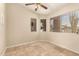 Neutral-toned room featuring tile flooring, ceiling fan, and natural light from the windows at 16288 W Hadley St, Goodyear, AZ 85338