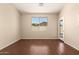 Spacious room with hardwood floors, a large window, and a glass panel door at 16288 W Hadley St, Goodyear, AZ 85338