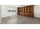 Bright living room with a wall of built-in cabinets, tile flooring, and a large window at 1712 N Old Colony --, Mesa, AZ 85201